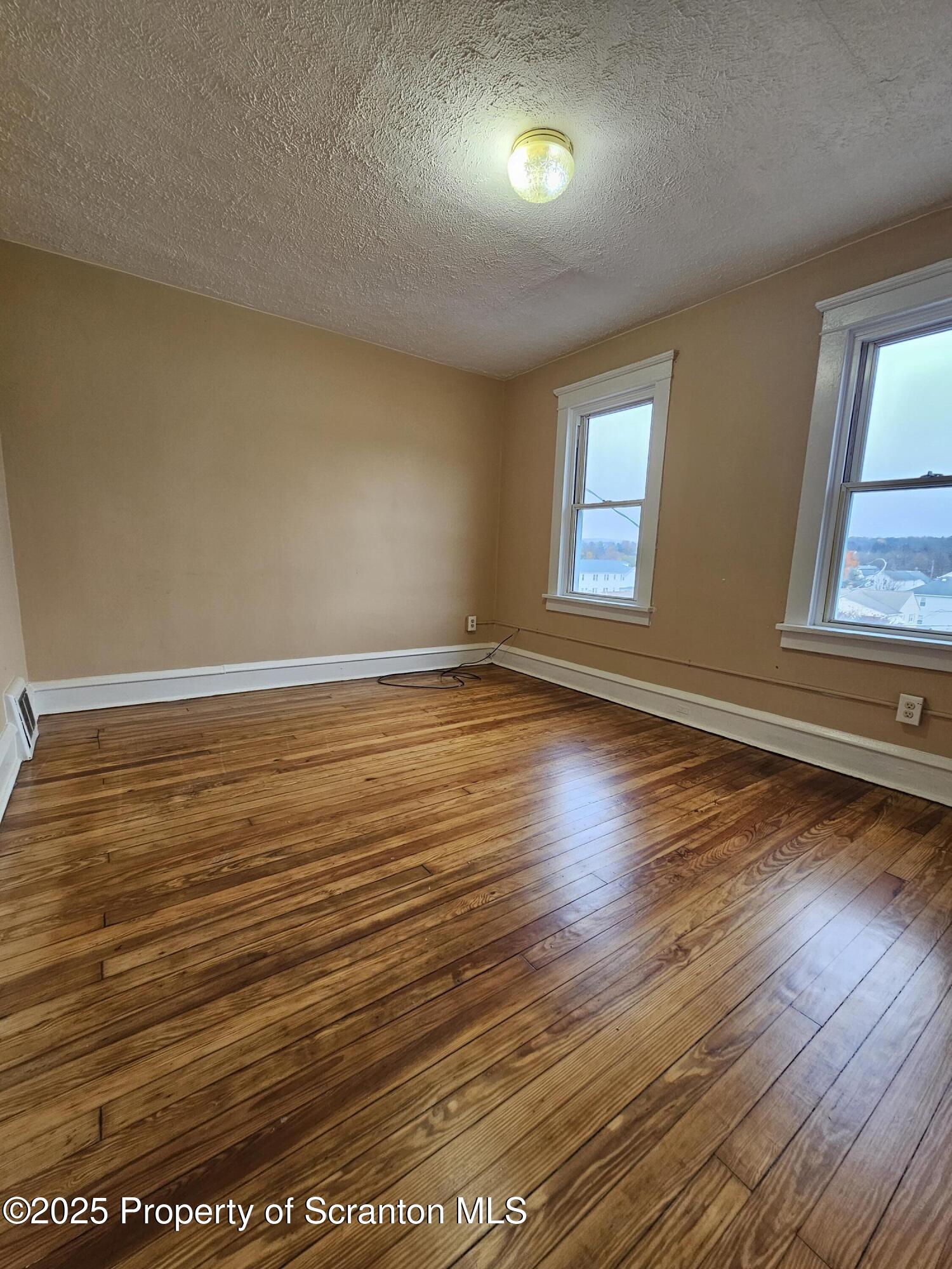 775 Bennett Street Luzerne, PA 18709 - Photo 14 of 18 an empty room with wooden floor and windows