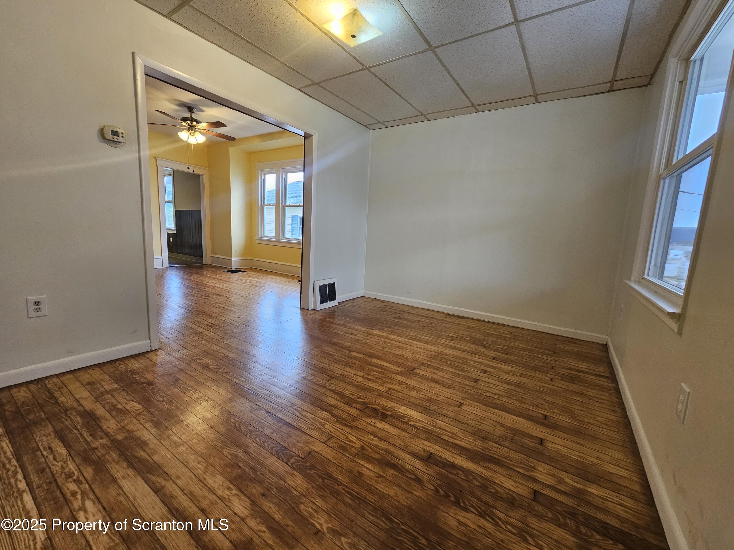 775 Bennett Street Luzerne, PA 18709 - Photo 2 of 18 a view of an empty room with wooden floor and a window
