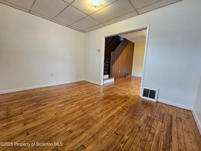a view of a livingroom with wooden floor and a ceiling fan