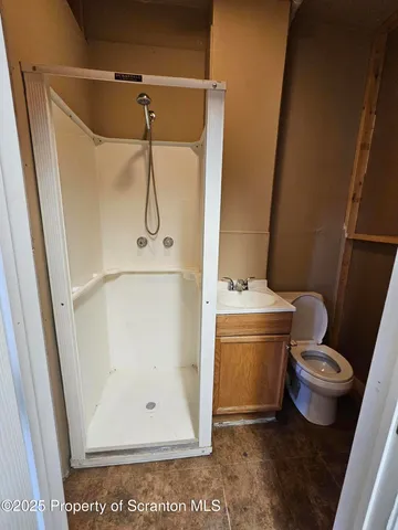 a bathroom with a granite countertop sink toilet and shower