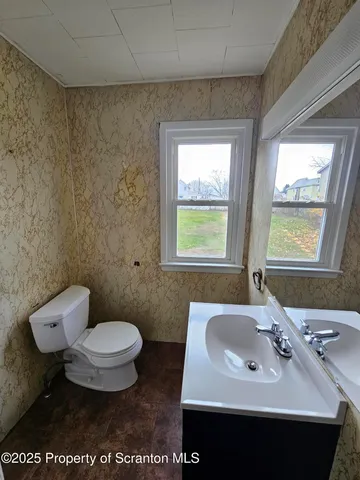 a bathroom with a sink toilet and a window