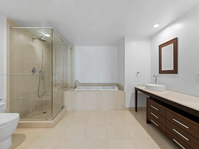 a spacious bathroom with a shower sink mirror and toilet