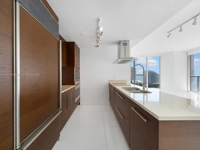 a kitchen with stainless steel appliances granite countertop a sink and a refrigerator