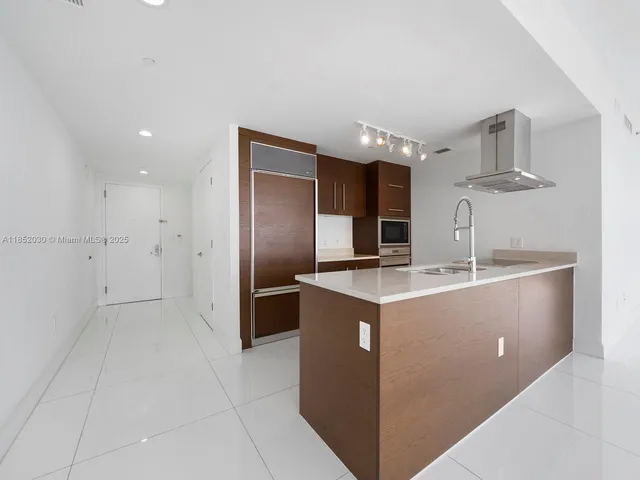 a kitchen with stainless steel appliances granite countertop a sink and a refrigerator