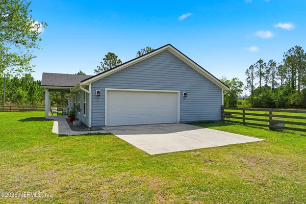 a view of a house with a yard and tree