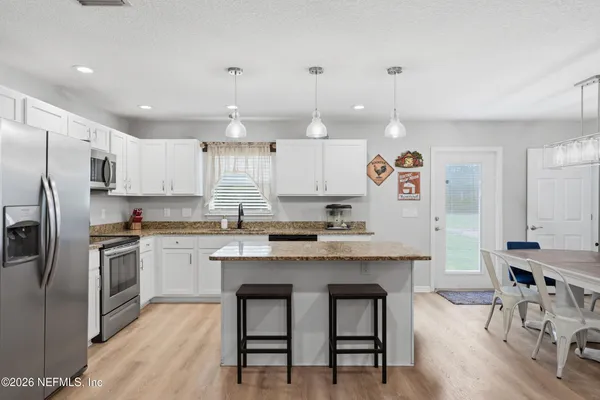 a kitchen with kitchen island granite countertop a sink a center island and stainless steel appliances