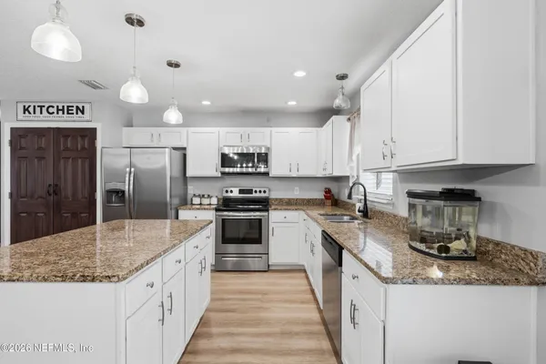 a kitchen with stainless steel appliances granite countertop a sink a stove and a refrigerator