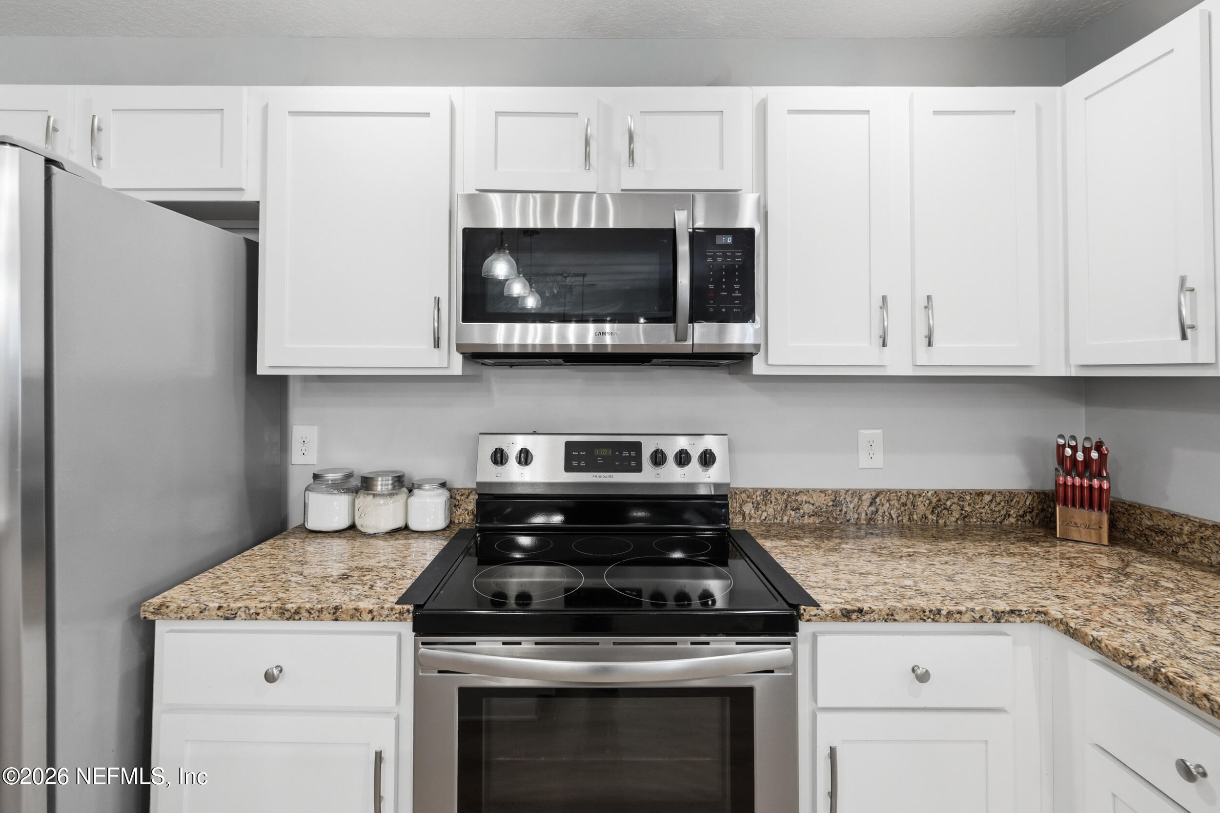 2471 Iris Street Middleburg, FL 32068 - Photo 10 of 40 a kitchen with granite countertop white cabinets and a stove a sink with dishwasher