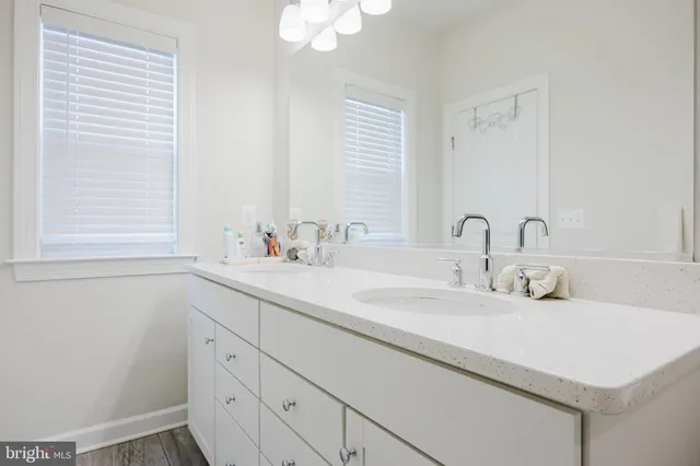 a bathroom with a sink a toilet and a large mirror