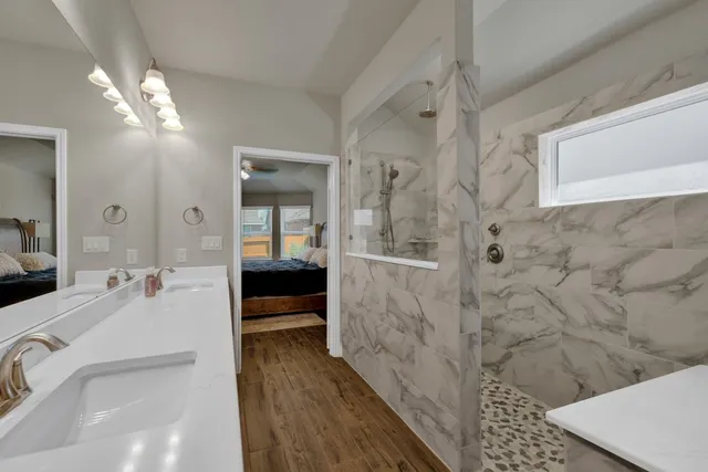 a en suite bathroom with a double vanity sink and a mirror