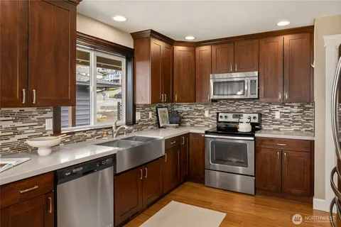 a kitchen with stainless steel appliances granite countertop a sink stove microwave and cabinets