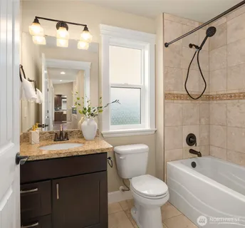 a bathroom with a sink vanity mirror toilet and bathtub