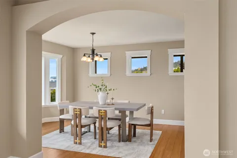 a dining room with wooden floor a chandelier a wooden table and chairs