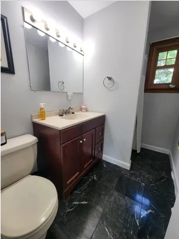 a bathroom with a toilet sink and mirror