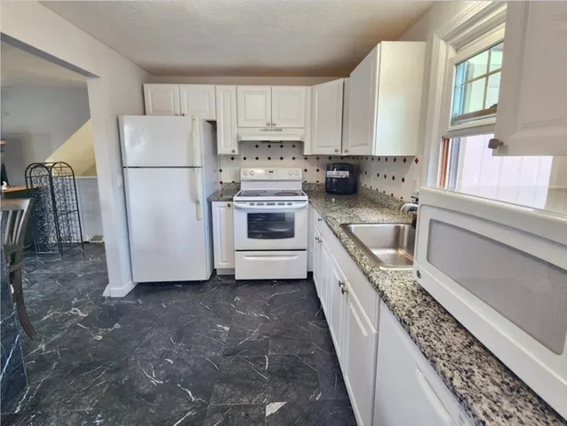 a kitchen with a white cabinets and white appliances