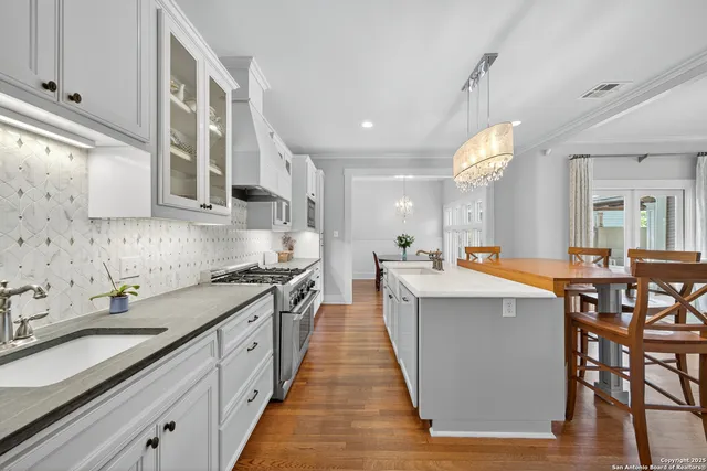 a kitchen with stainless steel appliances a sink stove and cabinets