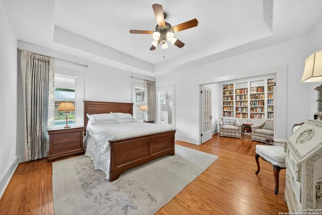a spacious bedroom with a bed a table and a chandelier