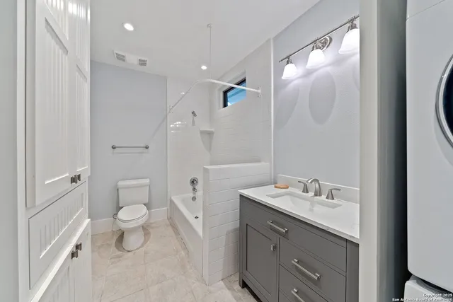 a bathroom with a sink a toilet a large mirror and shower