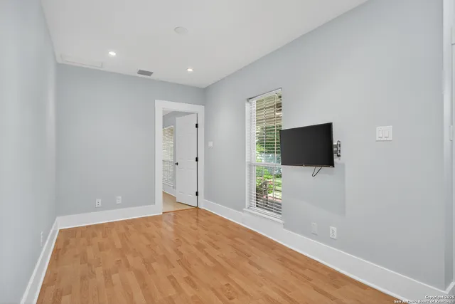 a view of a livingroom with wooden floor and a flat screen tv