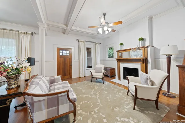a living room with furniture a fireplace and a chandelier