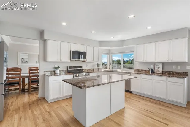 a kitchen with a sink cabinets and wooden floor
