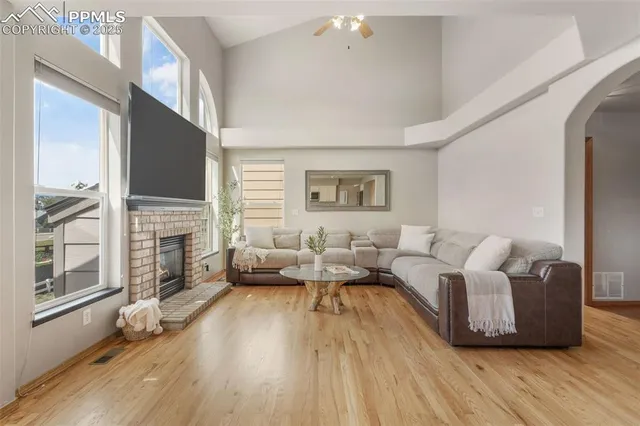 a living room with furniture large window and wooden floor