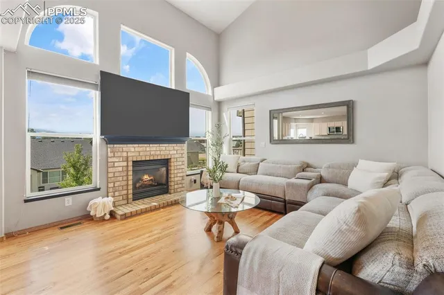 a living room with furniture a fireplace and a large window