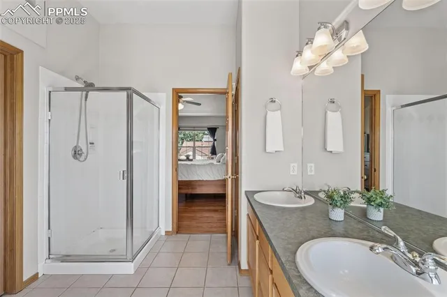 a bathroom with a granite countertop sink a mirror and shower