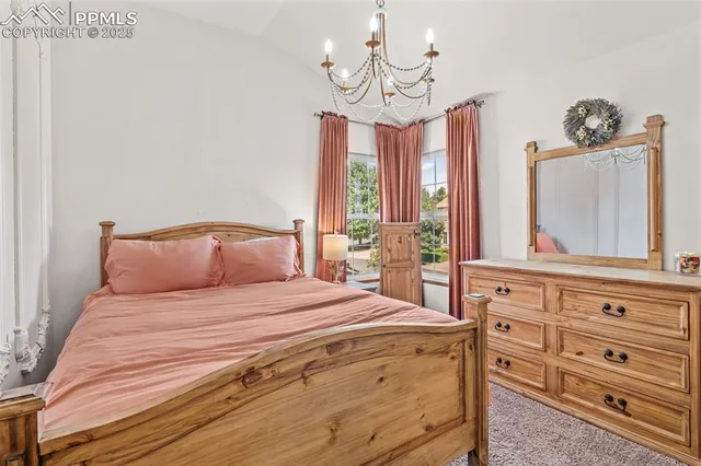 a bedroom with a large bed and a chandelier