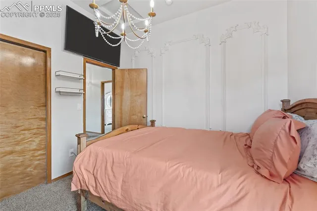 a bedroom with a bed and a chandelier
