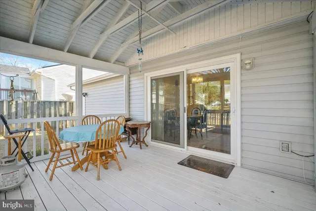 a view of a patio with table and chairs and floor to ceiling window with wooden floor