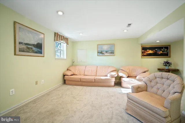 a living room with furniture and a wall painting