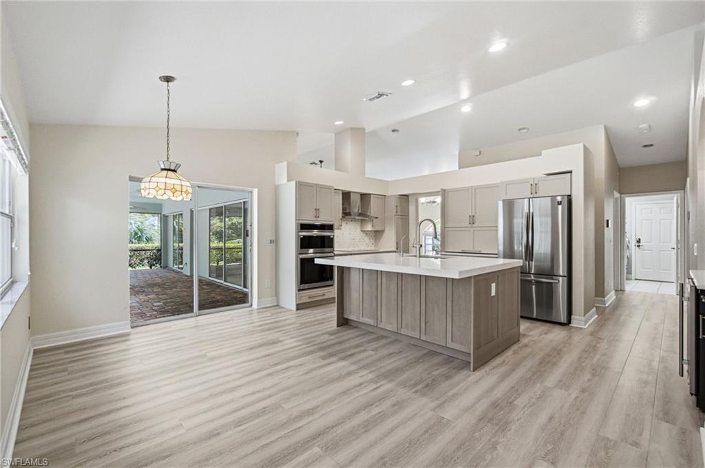 2053 17th Street Southwest Naples, FL 34117 - Photo 8 of 47 a large kitchen with kitchen island a large counter top and stainless steel appliances