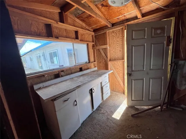 a view of an empty room with wooden floor and windows