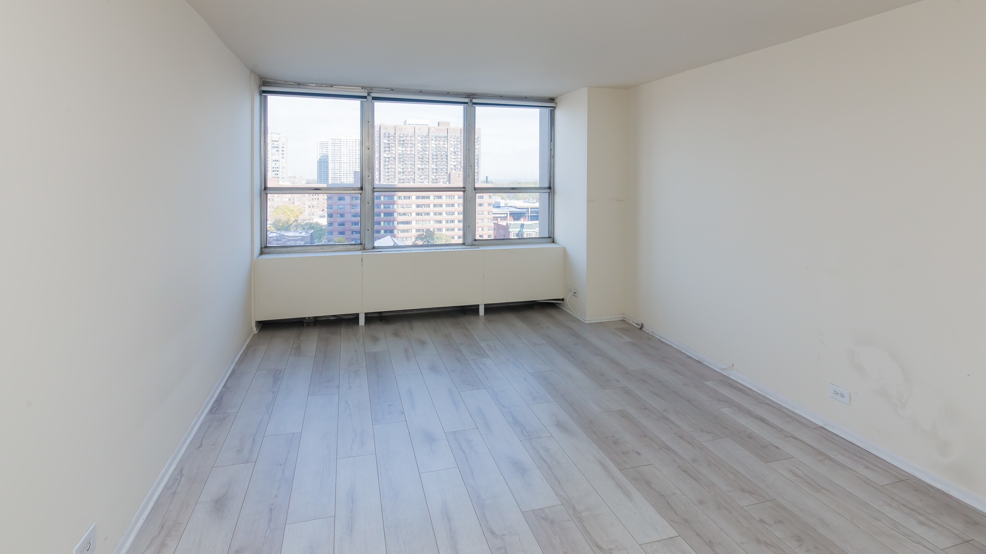 655 West Irving Park Road, Unit 1014 Chicago, IL 60613 - Photo 12 of 23 an empty room with wooden floor and windows