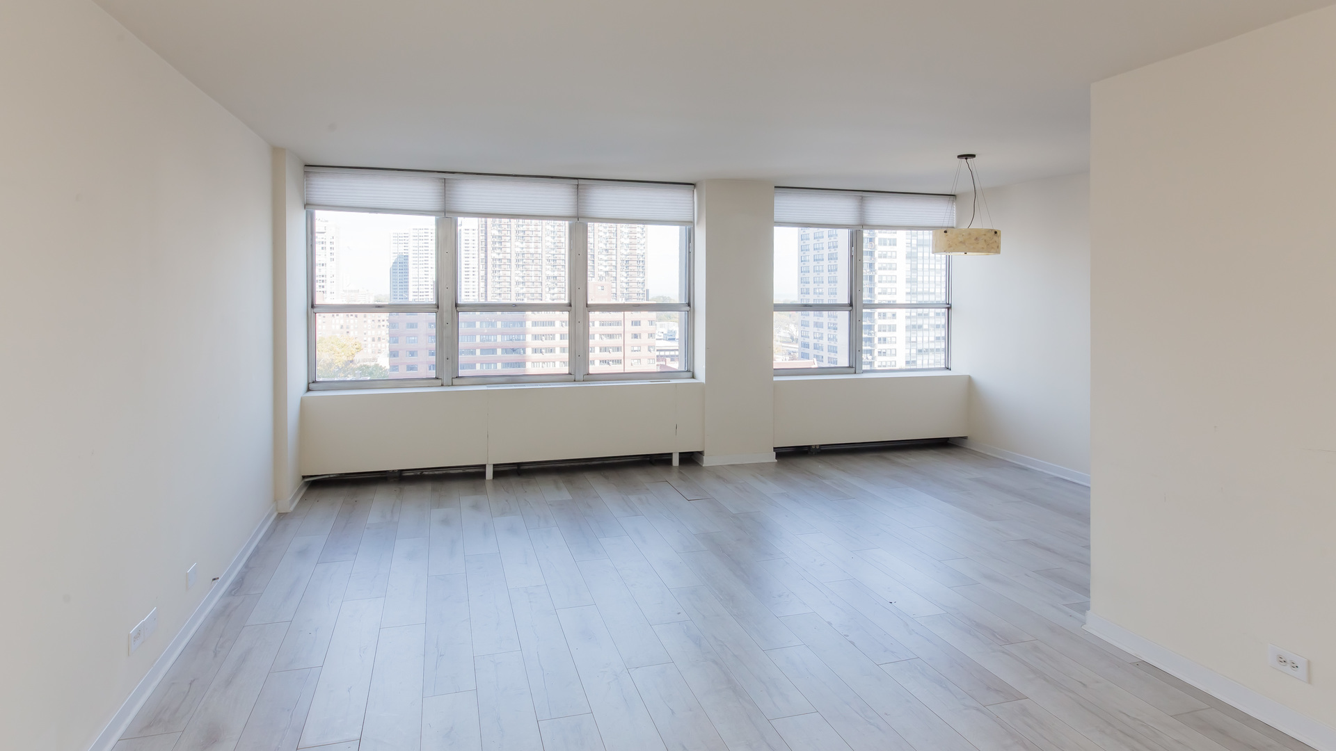 655 West Irving Park Road, Unit 1014 Chicago, IL 60613 - Photo 3 of 23 an empty room with wooden floor and windows