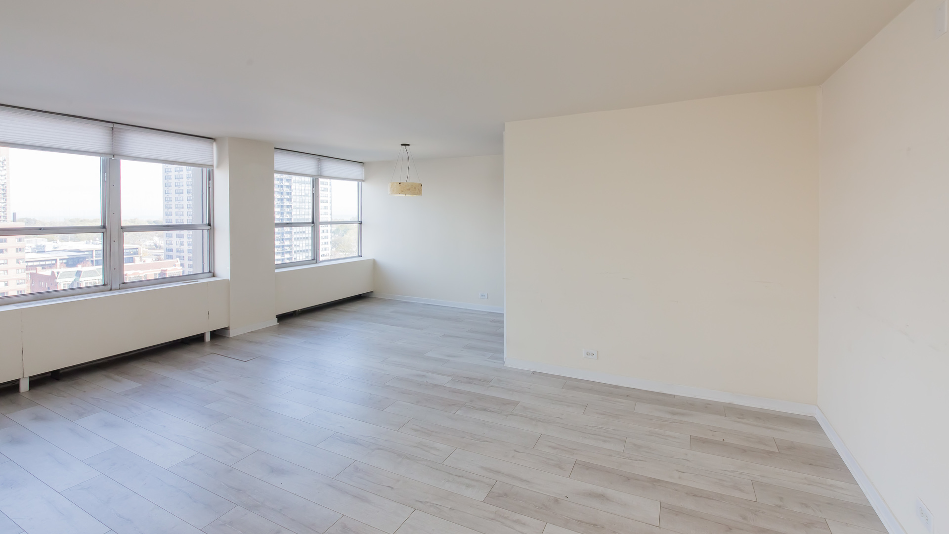 655 West Irving Park Road, Unit 1014 Chicago, IL 60613 - Photo 4 of 23 an empty room with wooden floor and windows