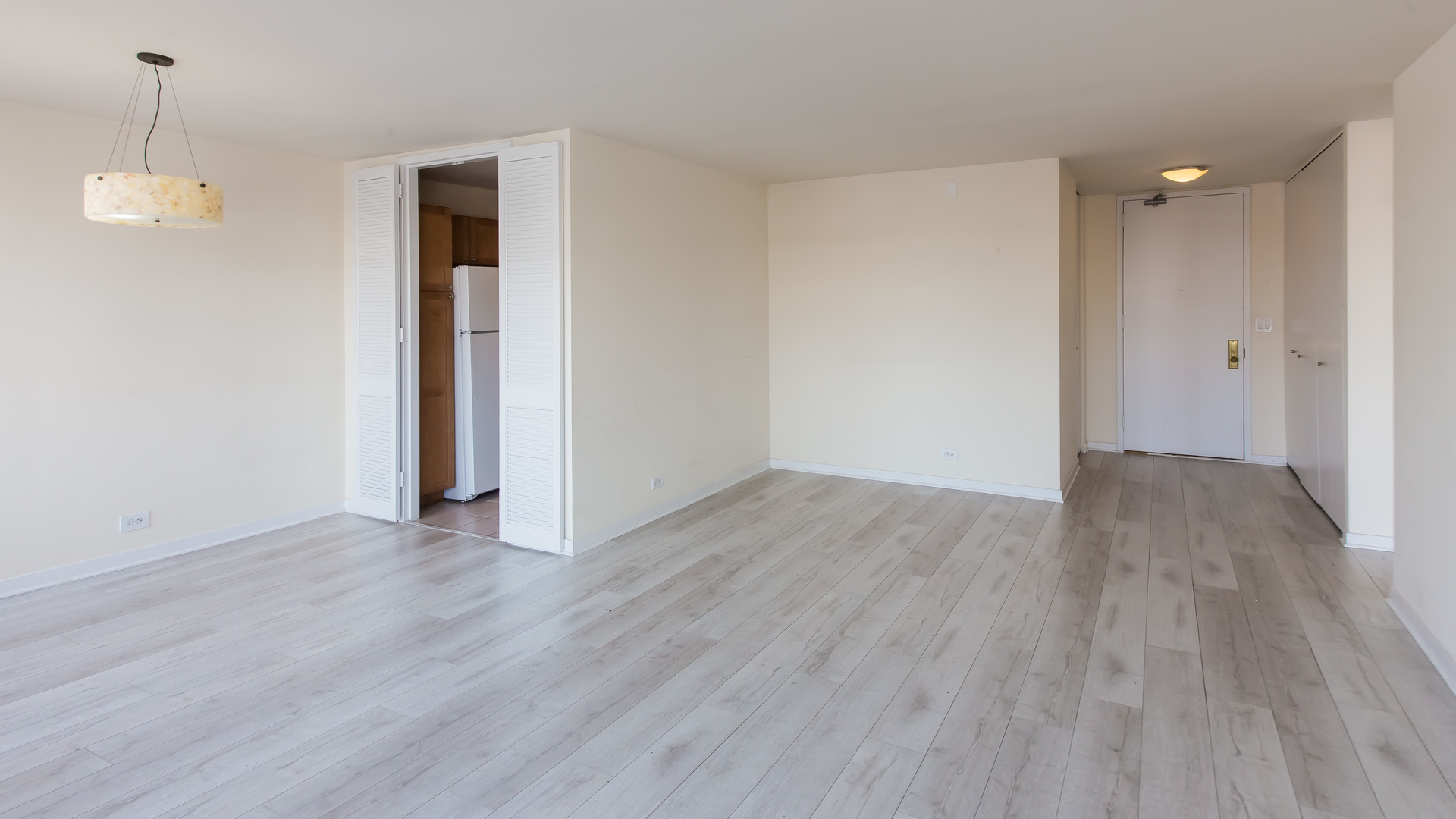 655 West Irving Park Road, Unit 1014 Chicago, IL 60613 - Photo 5 of 23 an empty room with wooden floor and windows