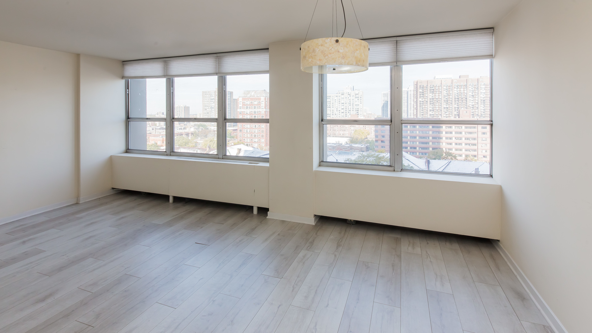 655 West Irving Park Road, Unit 1014 Chicago, IL 60613 - Photo 7 of 23 a view of an empty room with wooden floor and a window