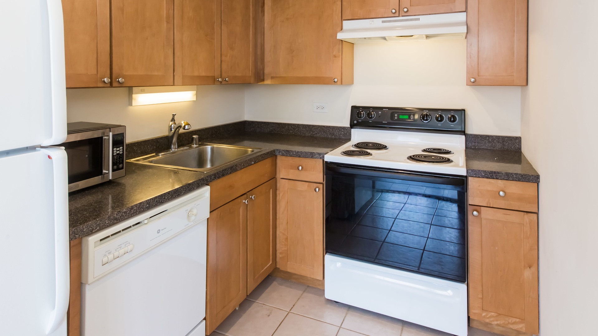 655 West Irving Park Road, Unit 1014 Chicago, IL 60613 - Photo 10 of 23 a kitchen with stainless steel appliances granite countertop a sink stove and refrigerator