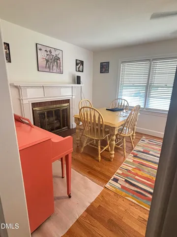 a dining room with furniture a fireplace and wooden floor