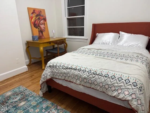 a bedroom with a bed and painting on the wall