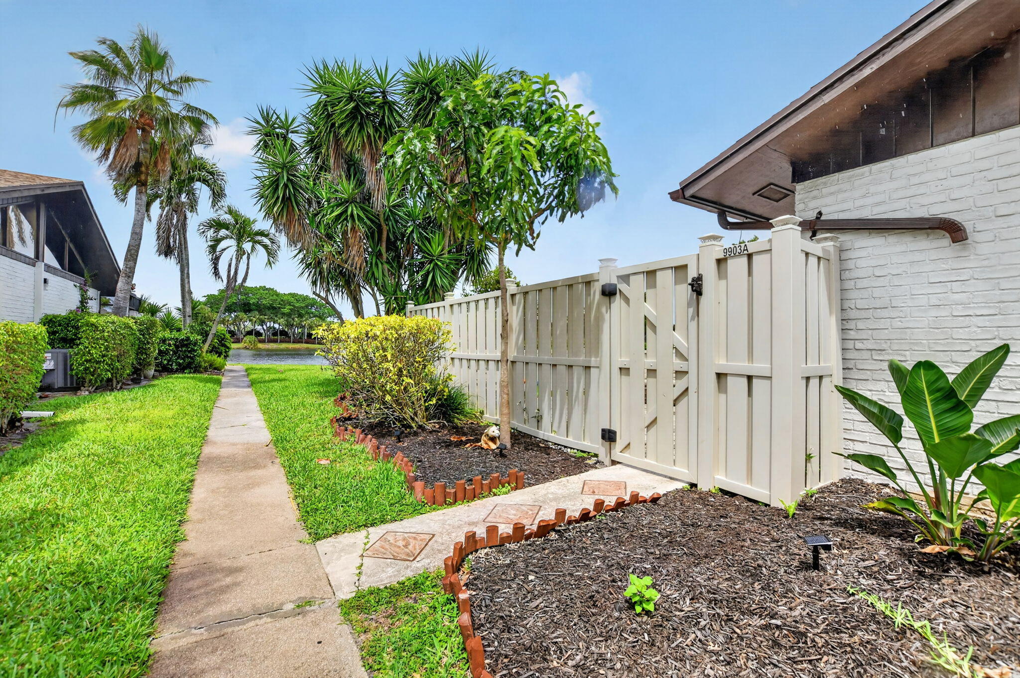 9903 Boca Gardens Trail Boca Raton, FL 33496 - Photo 5 of 37 a view of a pathway with a flower garden