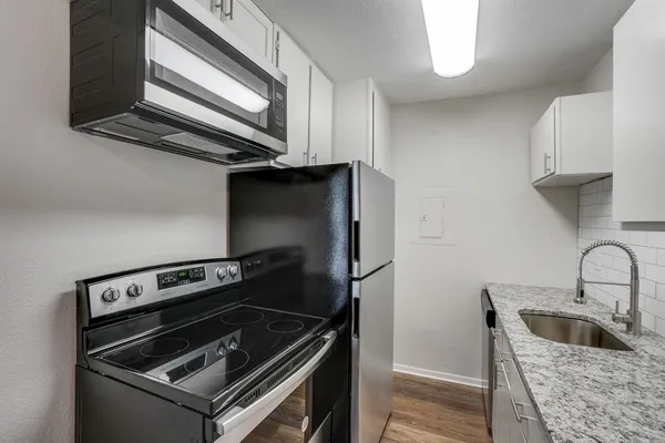 a kitchen with a stove microwave and sink
