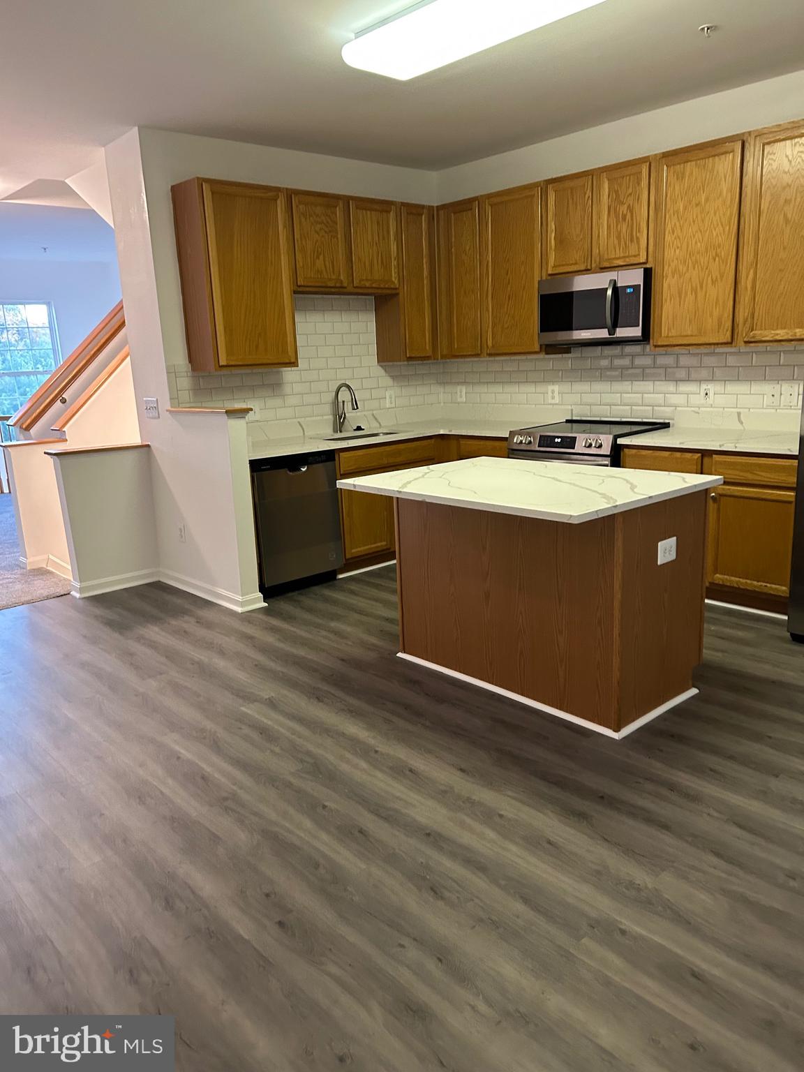 662 Luthardt Road Middle River, MD 21220 - Photo 21 of 52 a kitchen with kitchen island granite countertop a sink cabinets and wooden floor