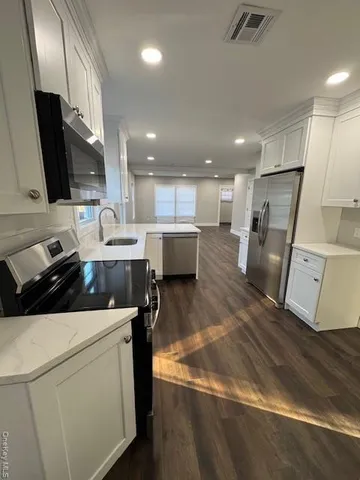 a kitchen with a sink a refrigerator and a stove top oven