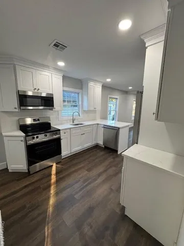 a kitchen with stove cabinets and wooden floor