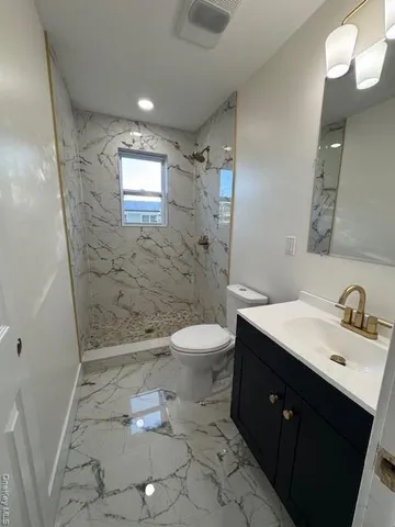 a bathroom with a sink a toilet a mirror and shower