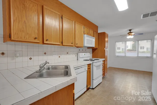 a kitchen with stainless steel appliances granite countertop a sink a stove and a refrigerator
