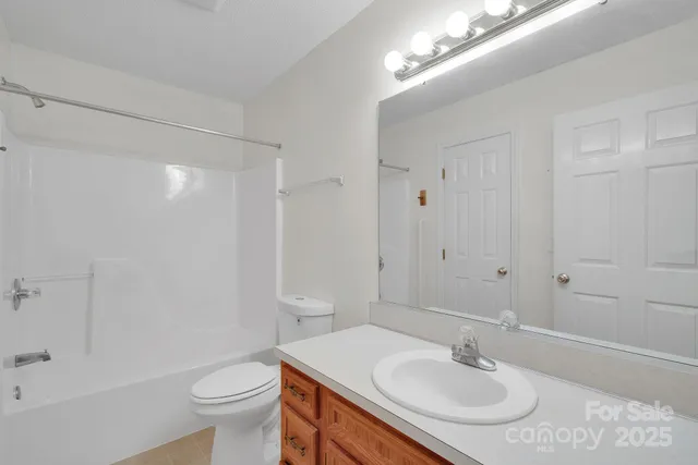 a bathroom with a sink toilet a mirror and shower